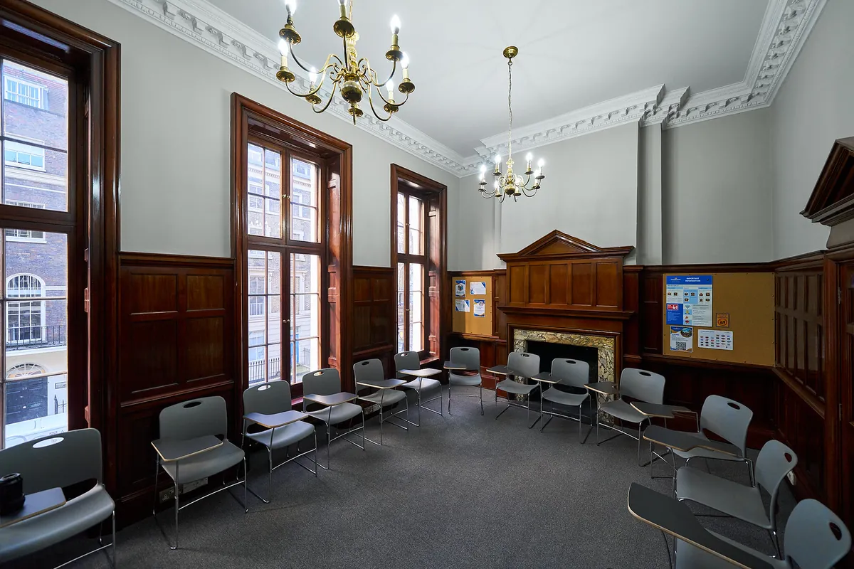 Sala lekcyjna z drewnianą boazerią, żyrandolem i ekranem w szkole w Londynie